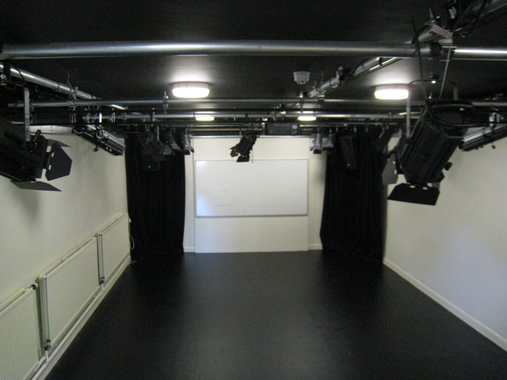 Classroom that is now a drama studio with drapes and lighting